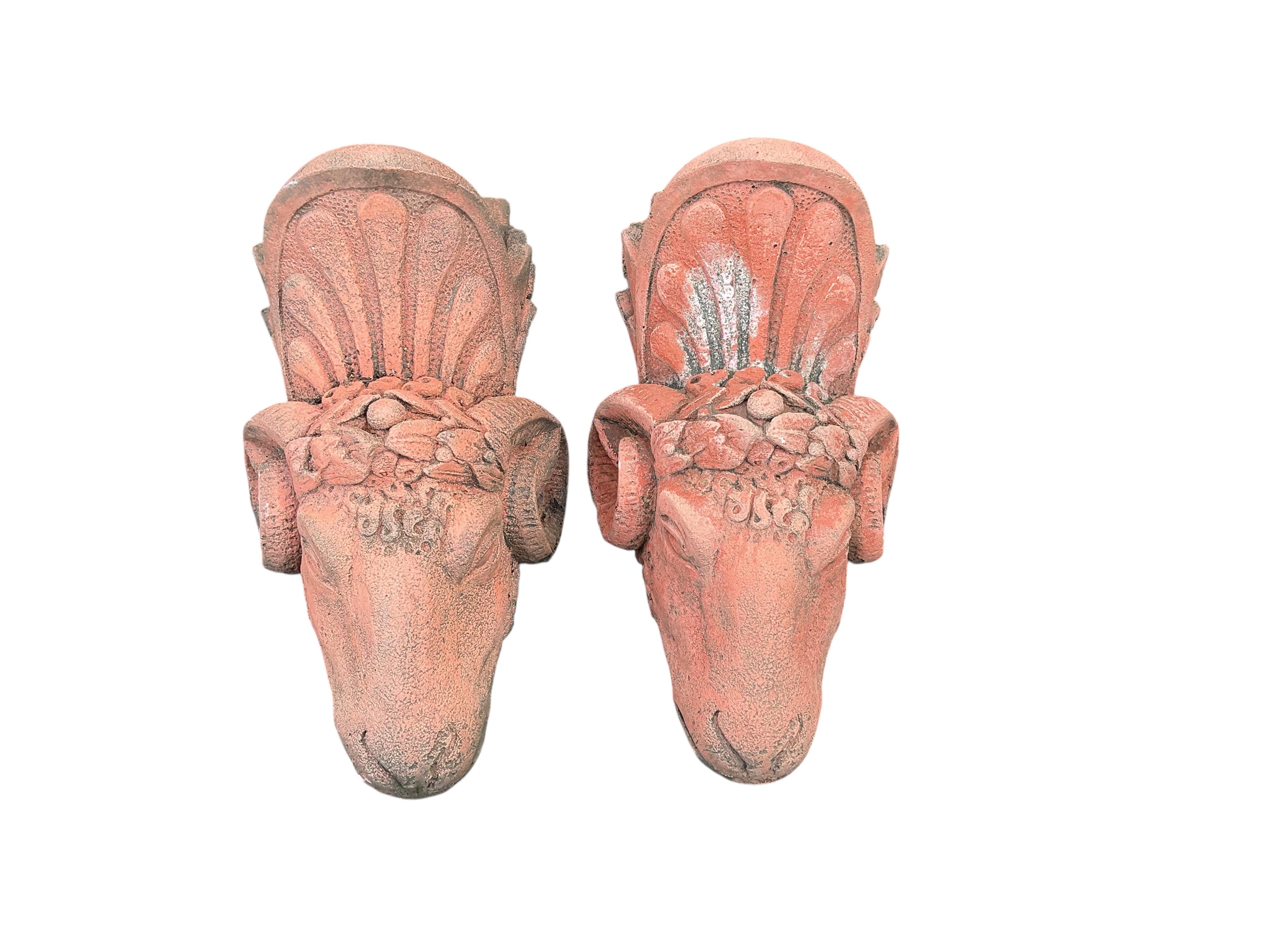 A pair of terracotta ram's head wall pockets, height 42cm